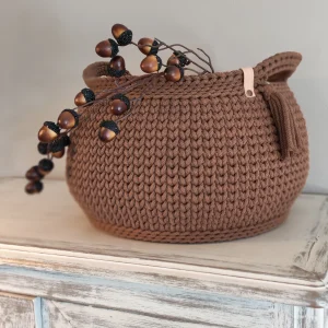 Panier crocheté à la main coloris noisette foncé, avec anse, pompon décoratif et étiquette en cuir “bobinensac” rivetée sur l’anse.